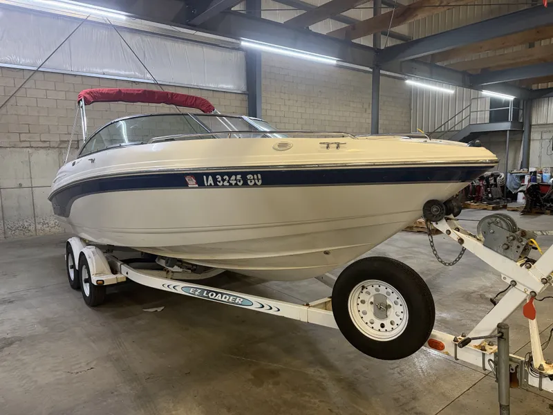 The Image of A 2001 Chaparral 219 boat on a trailer inside a warehouse. - 1