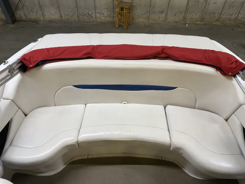 Slide: The Image of The rear seating of a 2001 Chaparral 219 boat with white upholstery and a red cover. - 15