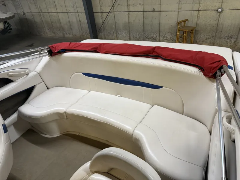 Slide: The Image of The image shows the white seating area of a 2001 Chaparral 219 boat with a red cover. - 16