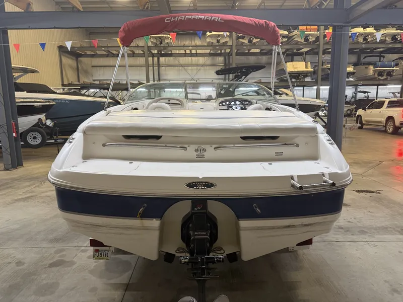 Slide: The Image of A 2001 Chaparral 219 boat in a storage facility, featuring a red sunshade. - 4