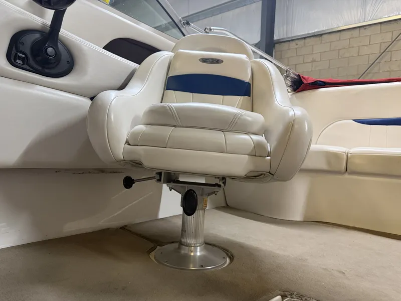 Slide: The Image of A white captain's chair with blue accents in a boat, surrounded by beige carpeting. - 28