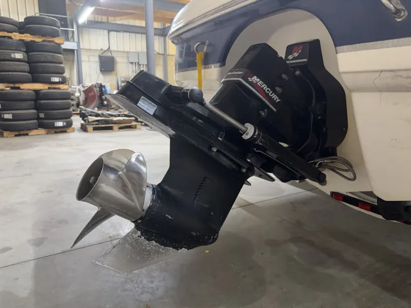 Slide: The Image of A Mercury outboard motor is mounted on a 2001 Chaparral 219 boat, in a warehouse setting. - 48