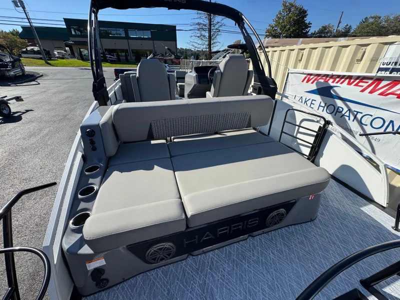 Slide: The Image of The image shows the rear of a Harris 230SOL pontoon boat with gray cushions and speakers. - 14