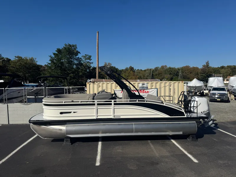Slide: The Image of A 2027 Harris 230SOL pontoon boat is parked in a lot. It features a sleek design. - 3