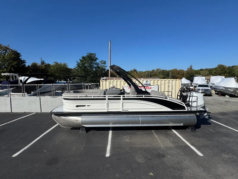 Slide: The Image of A 2027 Harris 230SOL pontoon boat is parked in a lot. It features a sleek design. - 1