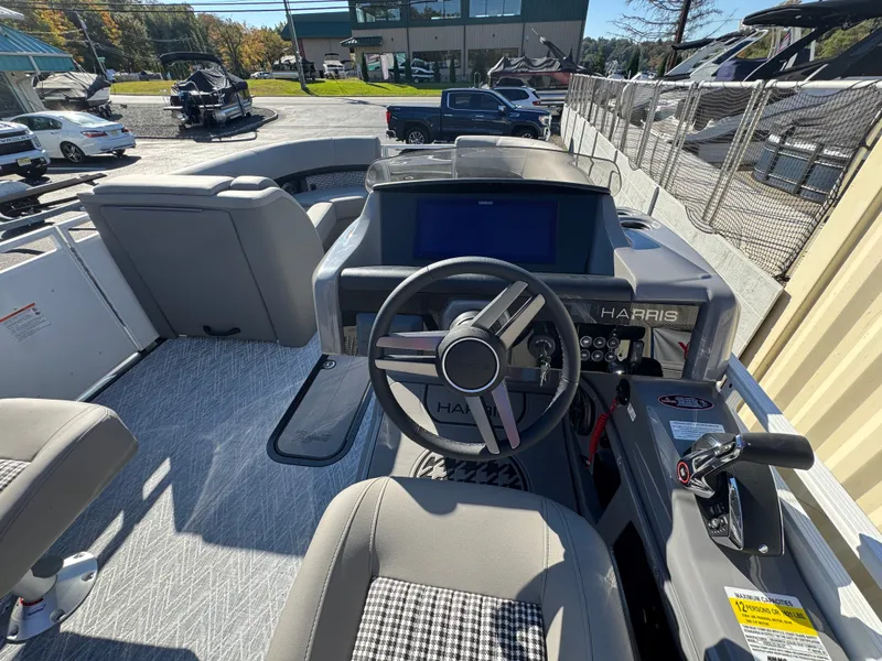 Slide: The Image of The image shows the cockpit of a Harris 230SOL boat with a modern steering wheel and large screen. - 22