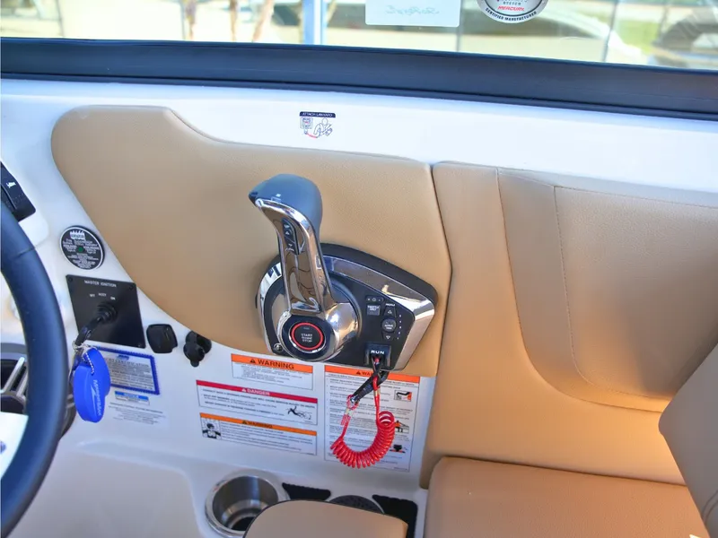 Slide: The Image of Close-up of a Sea Ray SDX 270 Surf control area with throttle and warning labels. - 31