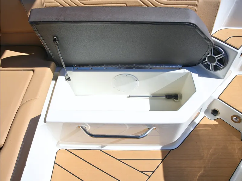 Slide: The Image of An open storage compartment on a Sea Ray SDX 270 Surf boat with brown upholstery. - 21