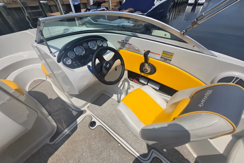 Slide: The Image of 2007 Sea Ray 185 Sport boat interior with yellow and gray seating, steering wheel, and dashboard. - 7