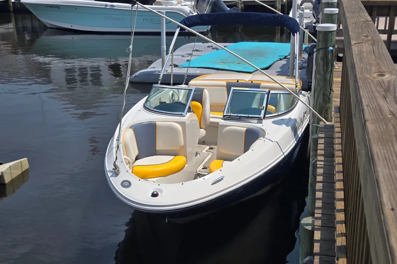Slide: The Image of 2007 Sea Ray 185 Sport boat docked, featuring yellow and white seating. - 4