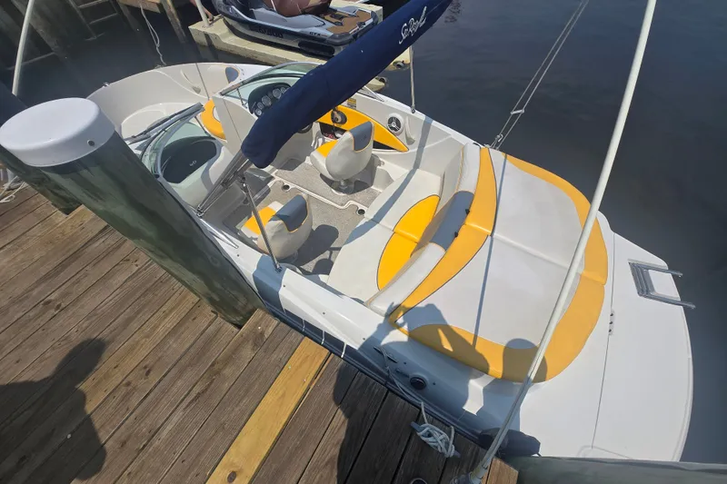 Slide: The Image of 2007 Sea Ray 185 Sport boat docked, featuring yellow and white seating, and a sleek design. - 3