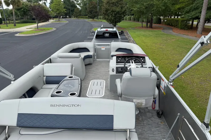 Slide: The Image of 2022 Bennington LX 22 Swingback pontoon boat interior with seating and steering console. - 22