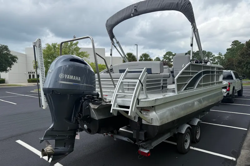 Slide: The Image of 2022 Bennington LX 22 Swingback pontoon boat with Yamaha outboard motor in parking lot. - 7