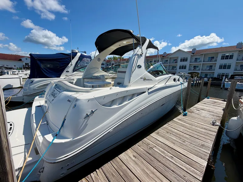 Slide: The Image of A 2003 Sea Ray Sundancer 320 docked at a wooden pier in a marina. - 2