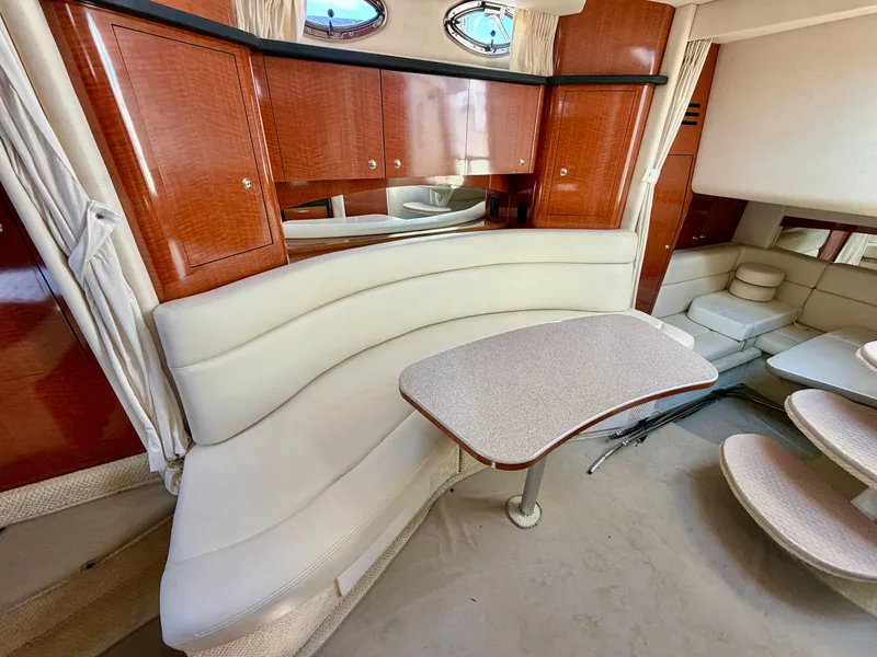 Slide: The Image of Interior of the 2003 Sea Ray Sundancer 320 with curved leather sofa and wooden cabinetry. - 14