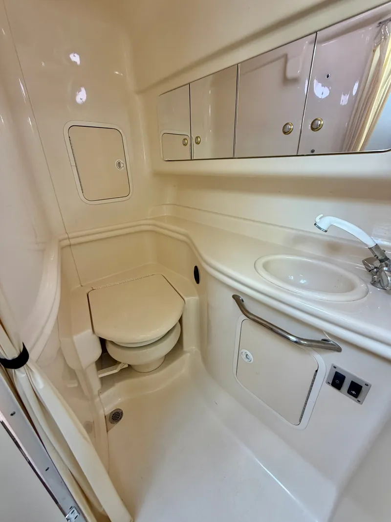 Slide: The Image of The image shows a clean boat bathroom with a toilet, sink, and storage cabinets. - 15