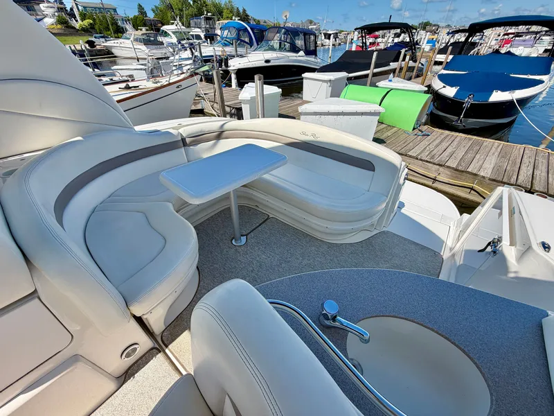 Slide: The Image of The image shows the cockpit of a 2003 Sea Ray Sundancer 320 with curved seating and a table. - 8