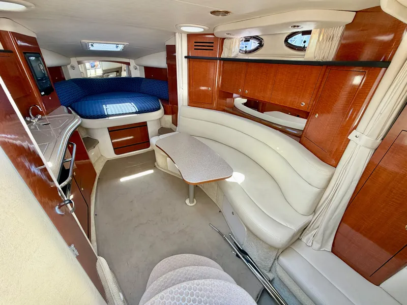 Slide: The Image of The 2003 Sea Ray Sundancer 320 cabin features a cozy seating area and a bed. - 9