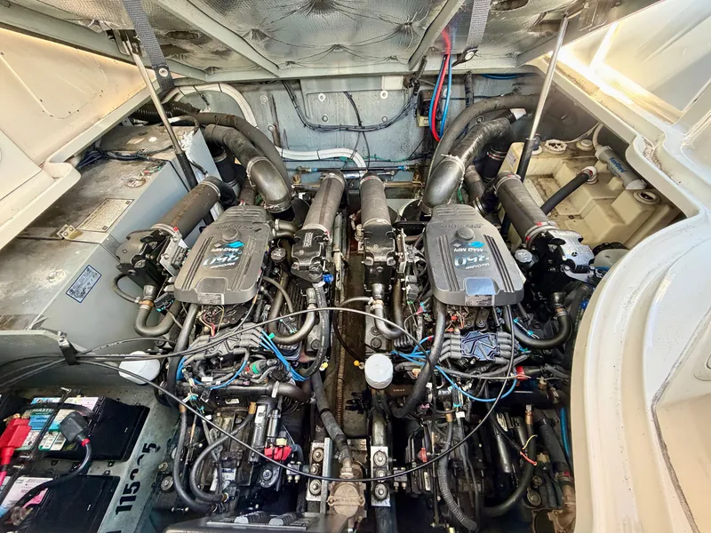 Slide: The Image of The engine room of a 2003 Sea Ray Sundancer 320 features two large engines and wiring. - 16