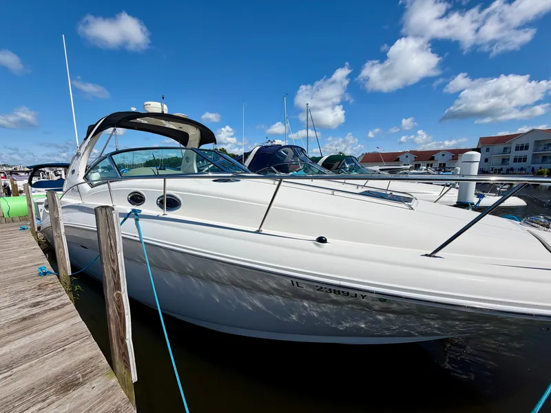 Slide: The Image of A 2003 Sea Ray Sundancer 320 docked at a marina. The sky is clear and blue. - 3