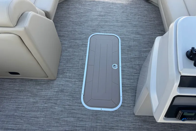Slide: The Image of Interior of 2027 Godfrey EX 2286 SBX boat with carpeted flooring and storage hatch. - 11