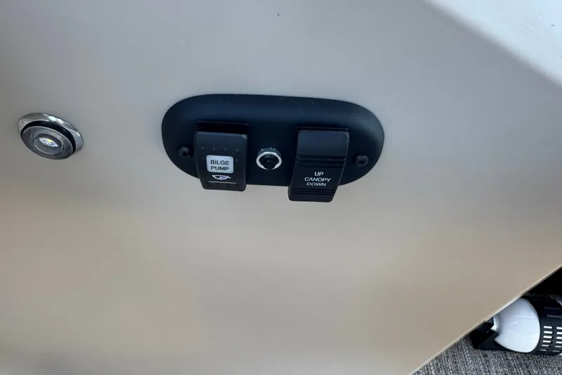 Slide: The Image of Control panel on a 2027 Godfrey EX 2286 SBX boat with bilge pump switch. - 13