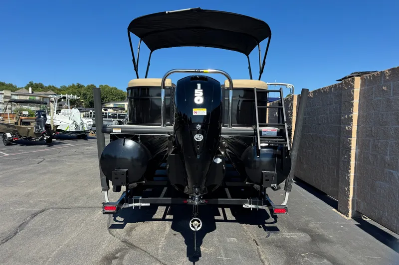 Slide: The Image of 2027 Godfrey EX 2286 SBX pontoon boat with 150 HP engine, parked outdoors. - 2