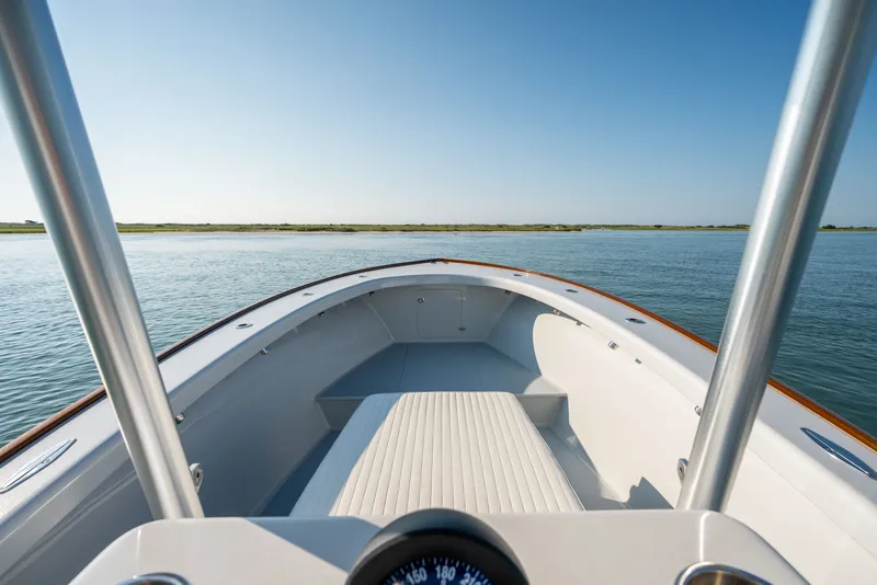 Slide: The Image of 2023 Harrison Boatworks 28 on calm water, showcasing sleek design and open deck. - 23
