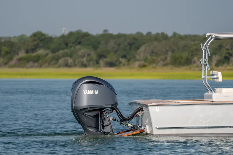 Slide: The Image of 2023 Harrison Boatworks 28 with Yamaha outboard motor on a serene lake. - 14