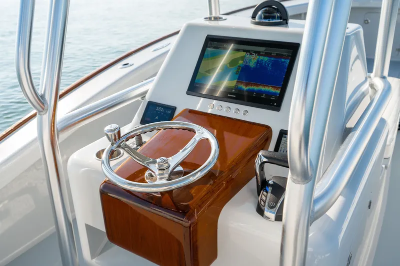 Slide: The Image of 2023 Harrison Boatworks 28 helm with modern navigation display and polished steering wheel. - 21
