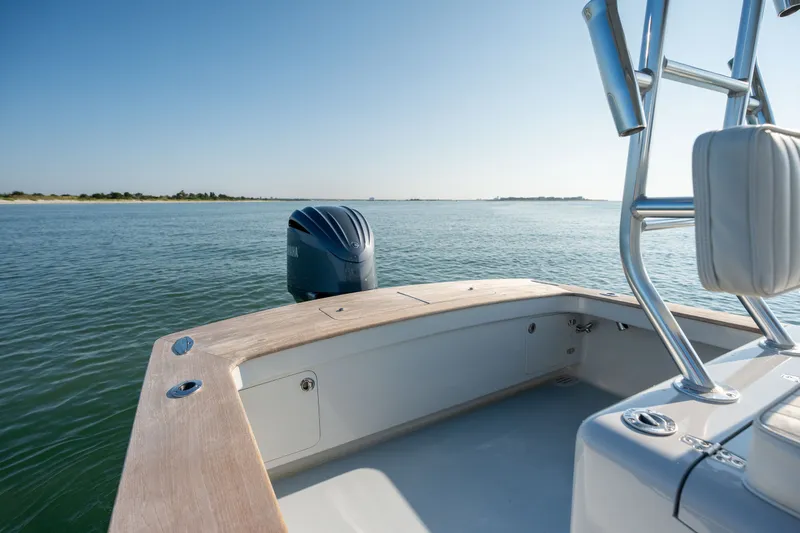 Slide: The Image of 2023 Harrison Boatworks 28 on calm water, featuring sleek design and modern outboard motor. - 26