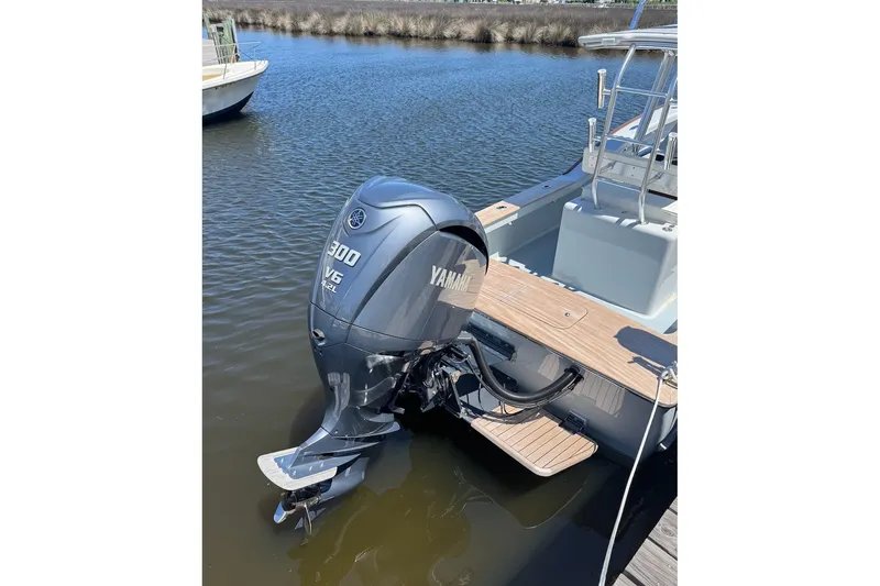 Slide: The Image of 2023 Harrison Boatworks 28 with Yamaha 300 V6 outboard motor, docked on calm water. - 3