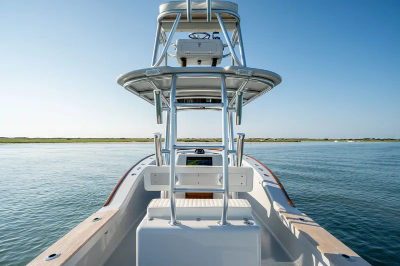 Slide: The Image of 2023 Harrison Boatworks 28 on calm water, showcasing helm and tower under clear sky. - 40