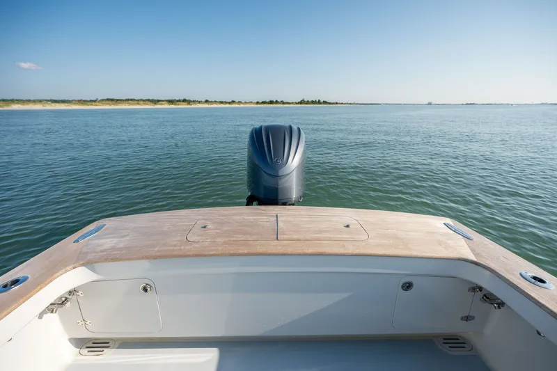 Slide: The Image of 2023 Harrison Boatworks 28 on calm water, showcasing sleek design and powerful outboard motor. - 7