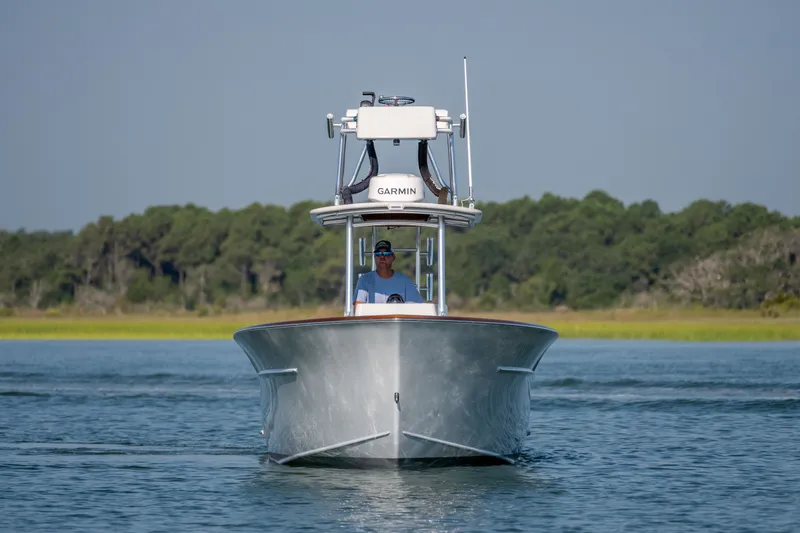 Slide: The Image of 2023 Harrison Boatworks 28 on water, front view with lush green background. - 3