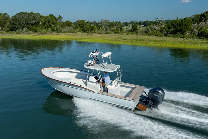 Slide: The Image of 2023 Harrison Boatworks 28 cruising on a serene lake with lush greenery. - 4