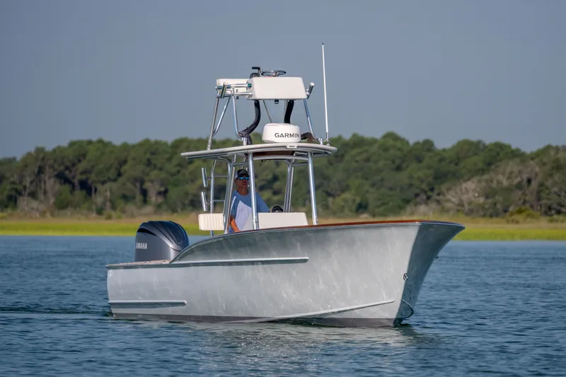 Slide: The Image of 2023 Harrison Boatworks 28 cruising on calm water with lush green shoreline. - 43