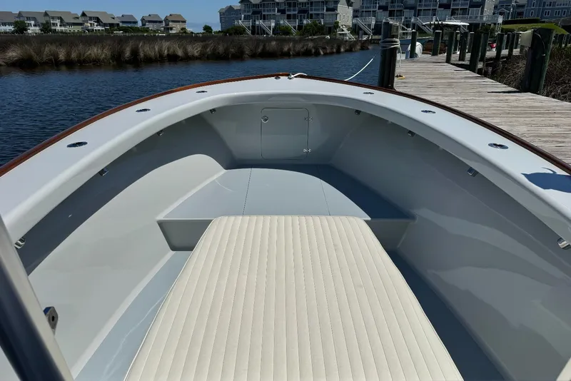Slide: The Image of 2023 Harrison Boatworks 28 interior with cushioned seating, dockside view. - 6