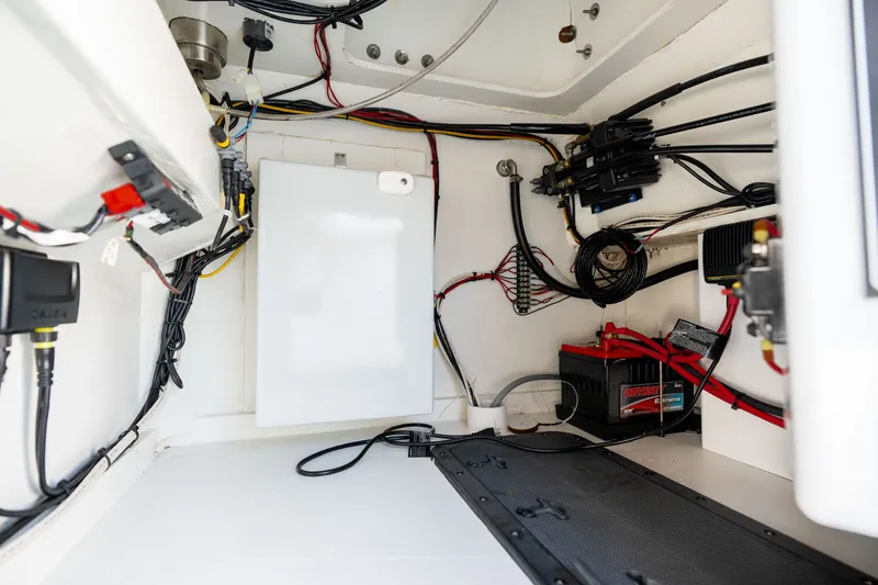Slide: The Image of Interior view of 2023 Harrison Boatworks 28, showcasing wiring and battery setup. - 51