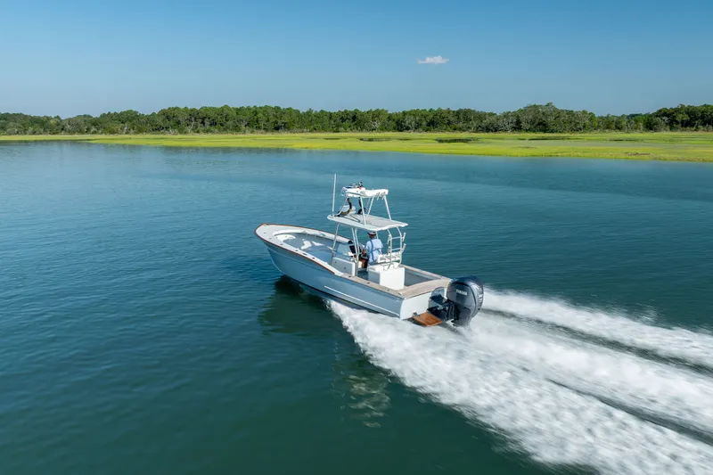 Slide: The Image of 2023 Harrison Boatworks 28 cruising on a serene lake under clear blue skies. - 33