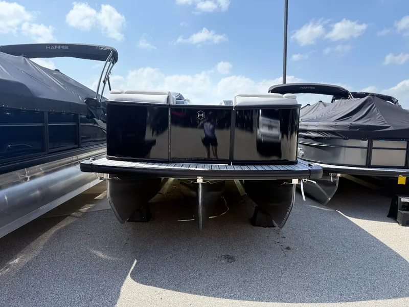 Slide: The Image of A 2027 Harris FloteBote SUNLINER 230 TRI-TOON SLDH is parked. It features three hulls and a sleek black rear. - 2