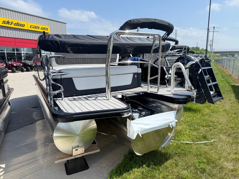 Slide: The Image of A 2027 Harris FloteBote SUNLINER 230 TRI-TOON SLDH is parked. It features a sleek design with a black Bimini top and stainless steel railings. - 4