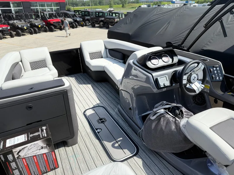 Slide: The Image of The image shows the cockpit of a 2027 Harris FloteBote SUNLINER 230 TRI-TOON SLDH with modern seating and a sleek helm. - 7