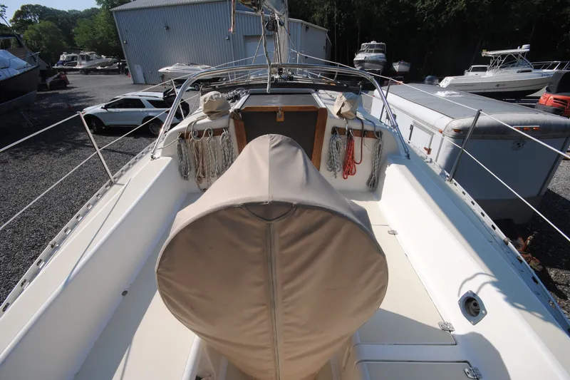 Slide: The Image of 1987 Tillotson-Pearson 28 sailboat cockpit with covered wheel, docked in a marina. - 6