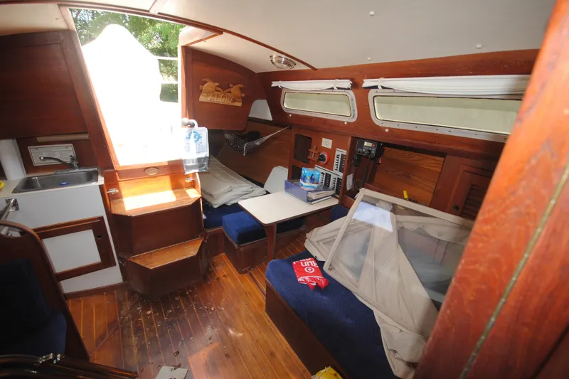 Slide: The Image of Interior of a 1987 Tillotson-Pearson 28 sailboat with wooden finishes and seating area. - 12