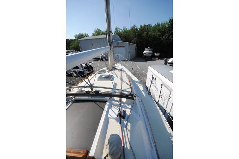 Slide: The Image of 1987 Tillotson-Pearson 28 sailboat deck view, docked near storage buildings. - 5