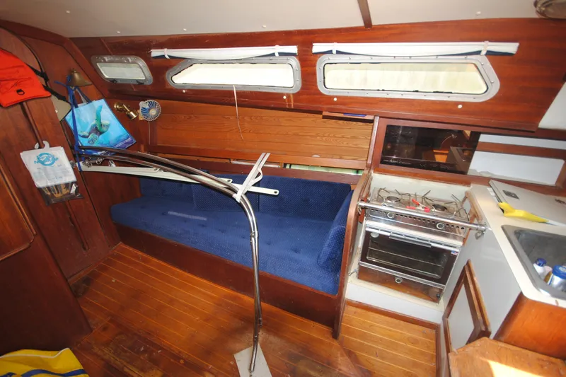 Slide: The Image of Interior of 1987 Tillotson-Pearson 28 sailboat with wooden finish and compact kitchen area. - 17