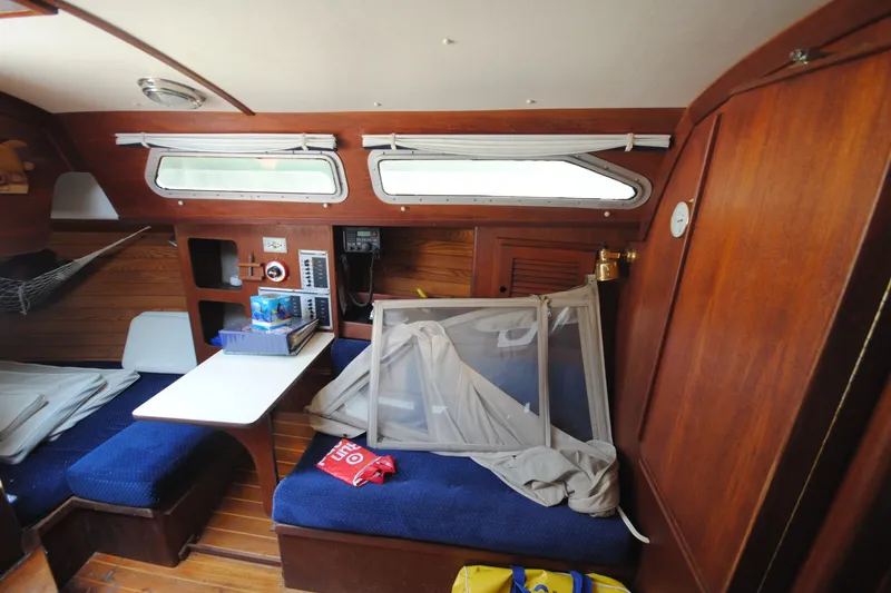 Slide: The Image of Interior of a 1987 Tillotson-Pearson 28 sailboat with wooden paneling and seating area. - 13