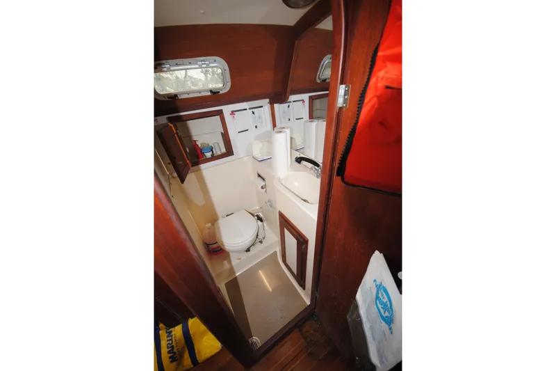 Slide: The Image of 1987 Tillotson-Pearson 28 boat interior bathroom with wooden accents and compact design. - 19
