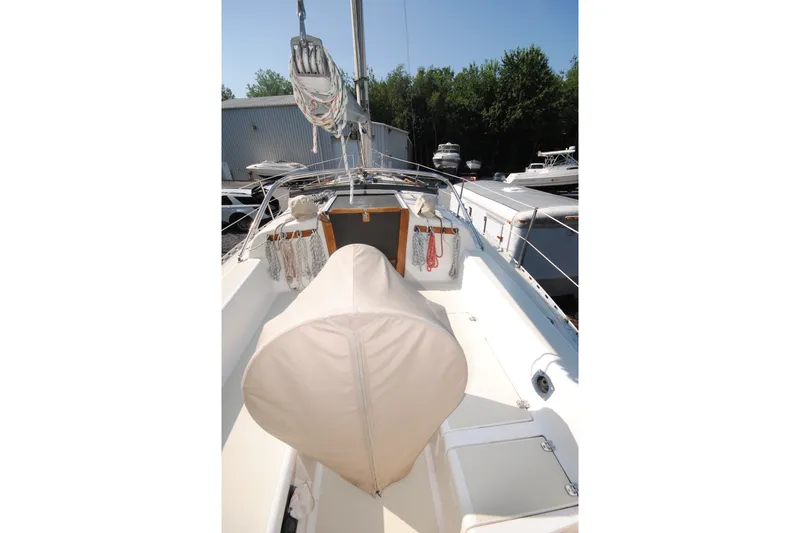 Slide: The Image of 1987 Tillotson-Pearson 28 sailboat cockpit with covered helm, docked near other boats. - 7